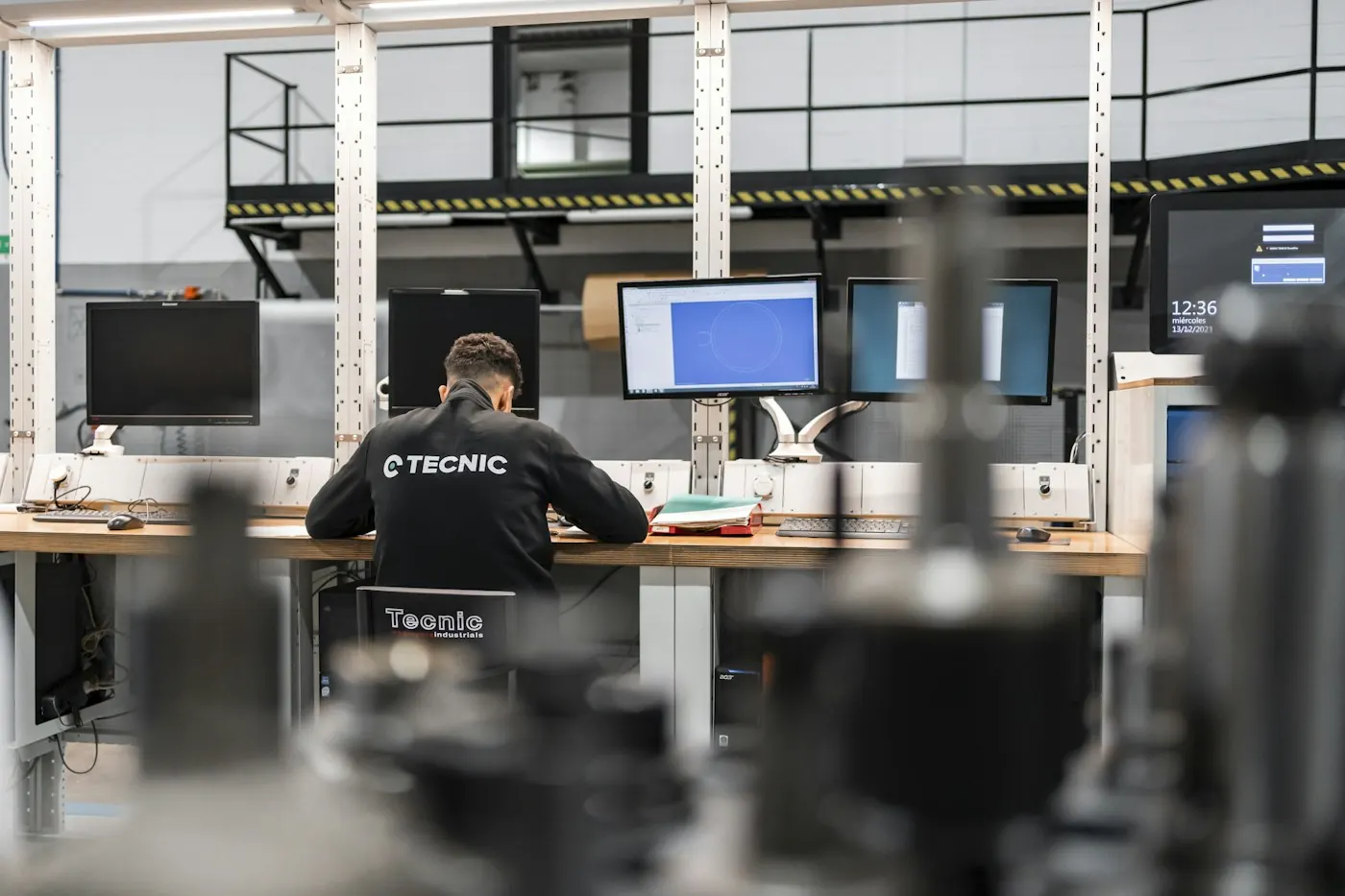 Poste de travail multi-écrans installé dans un atelier de production